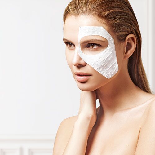 mujer joven con el pelo mojado peinado hacia atrás. lleva una masacrilla puesta en la mitad de la cara. tiene la mano derecha apoyada sobre su cuello